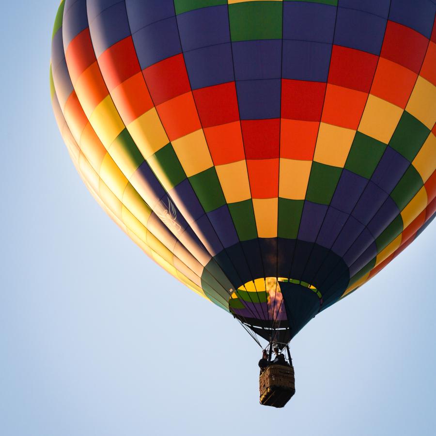 A hot air balloon viewed from below, with fire roaring from the burner. 