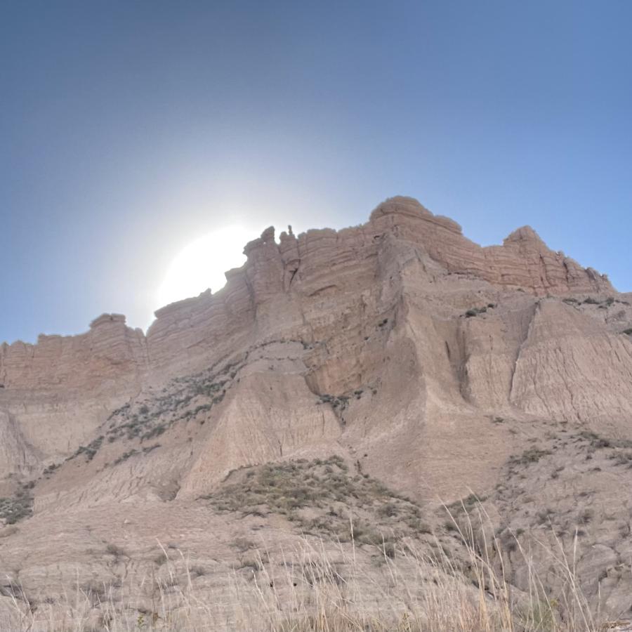 sun peaking above rock formations